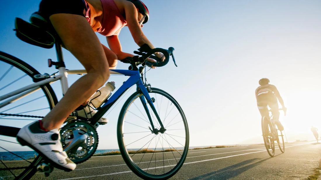 Competition cyclists riding in line on paved road