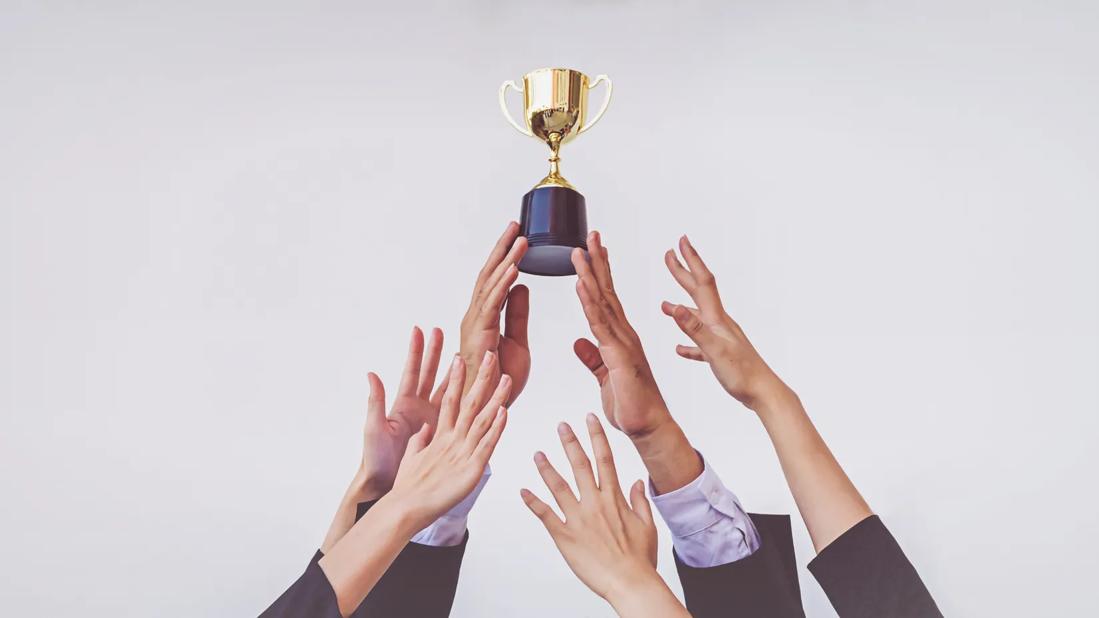 Hands holding up and reaching for a trophy