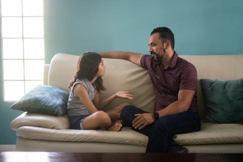 Child talking with caregiver on couch