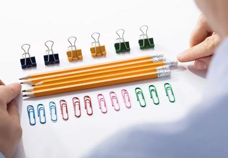 Man arranges office supplies for perfect look.