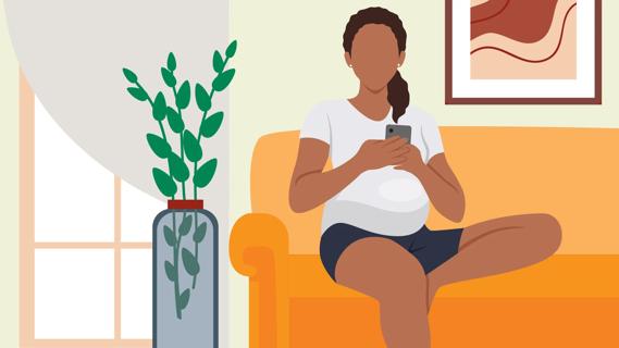 Pregnant woman sitting on sofa, looking on her phone