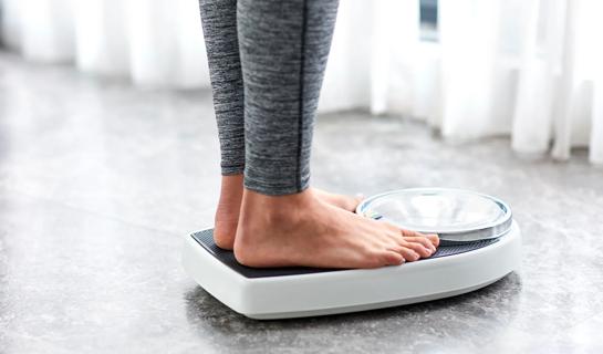 Person's feet and legs on a scale