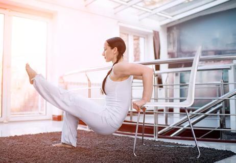 woman doing tricep exercise with a chair